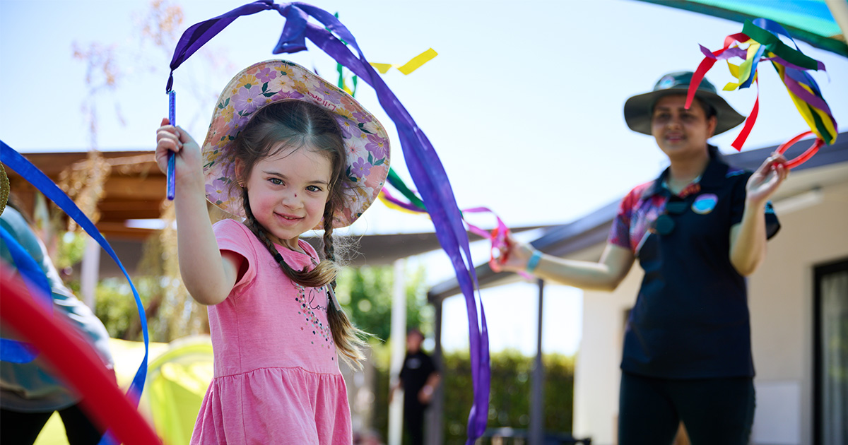 A young girl at a playcentre smiling at the camera