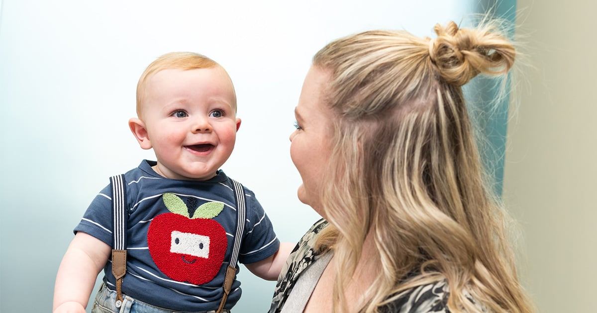 A smiling child held by a woman